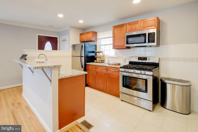 3312 Clay St, Silver Spring, MD 20902 - kitchen featuring stainless steel appliances, light stone counters, recessed lighting, a kitchen breakfast bar, and a center island with sink