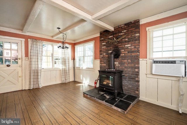 41 Collins Rd, Hamilton, NJ 08619 - unfurnished living room with dark wood-style flooring, beamed ceiling, a wood stove, a wainscoted wall, and a chandelier