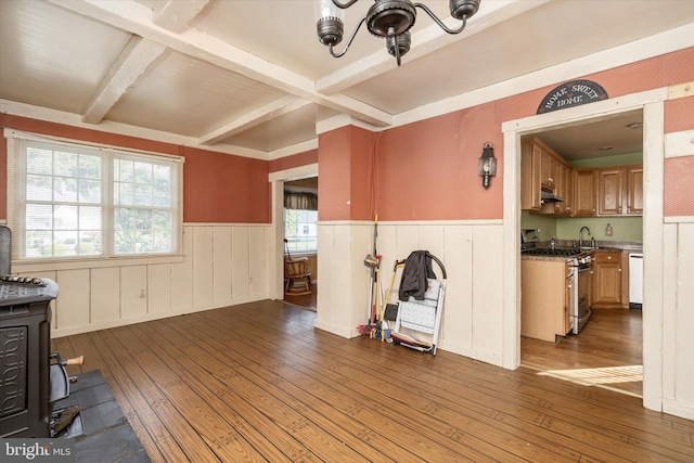 41 Collins Rd, Hamilton, NJ 08619 - unfurnished living room featuring a wainscoted wall, hardwood / wood-style flooring, beam ceiling, a chandelier, and a wood stove