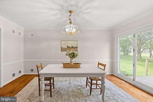98 Magnificent Ln, Hedgesville, WV 25427 - dining area featuring wood finished floors, ornamental molding, a chandelier, and baseboards