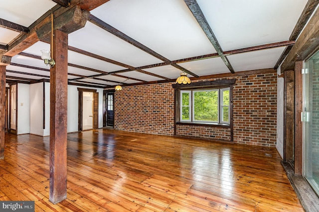 6908 S Roxbury Mill Rd, Spotsylvania, VA 22551 - unfurnished living room featuring brick wall, wood-type flooring, and beam ceiling