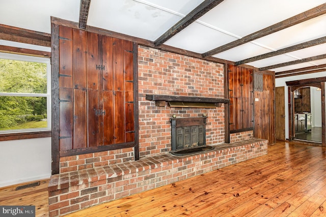 6908 S Roxbury Mill Rd, Spotsylvania, VA 22551 - unfurnished living room featuring beamed ceiling, wood-type flooring, wooden walls, and a fireplace
