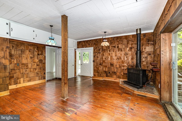 6908 S Roxbury Mill Rd, Spotsylvania, VA 22551 - unfurnished living room featuring wooden walls, hardwood / wood-style flooring, a wood stove, and baseboards