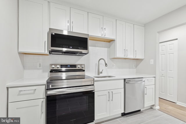 1205 Mirga Cir, Baltimore, MD 21207 - kitchen with stainless steel appliances, a sink, light countertops, backsplash, and white cabinetry