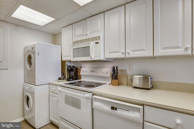 506 Brandywine House Rd Unit 506S, Bethany Beach, DE 19930 - kitchen featuring white appliances, stacked washer / dryer, white cabinets, a drop ceiling, and light countertops