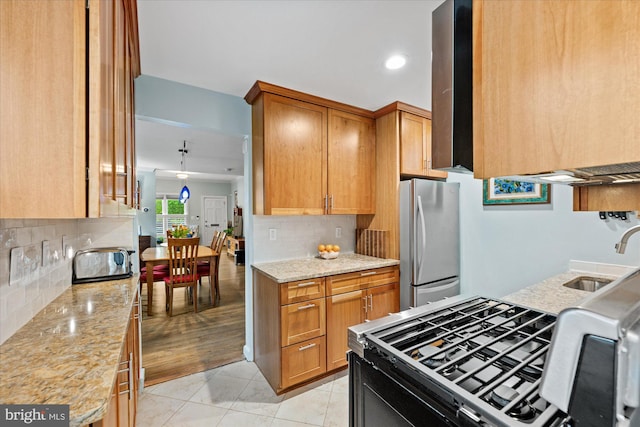 303 N W St, Alexandria, VA 22314 - kitchen with freestanding refrigerator, a sink, tasteful backsplash, light stone counters, and black range with gas cooktop