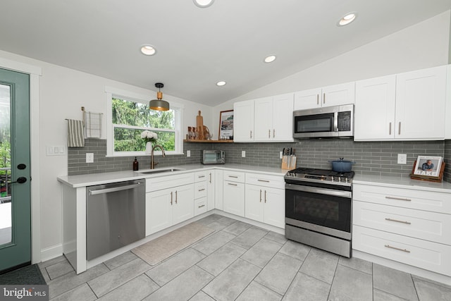 7 High St, Phoenixville, PA 19460 - kitchen with stainless steel appliances, a sink, vaulted ceiling, light countertops, and decorative backsplash