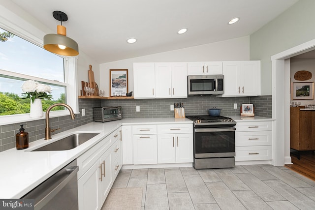 7 High St, Phoenixville, PA 19460 - kitchen with appliances with stainless steel finishes, a sink, light countertops, white cabinetry, and vaulted ceiling