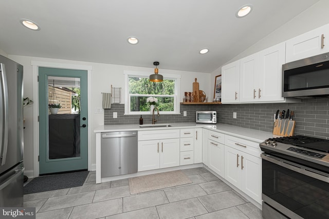 7 High St, Phoenixville, PA 19460 - kitchen featuring stainless steel appliances, light countertops, tasteful backsplash, a sink, and vaulted ceiling