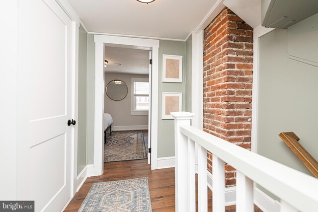 7 High St, Phoenixville, PA 19460 - hallway with wood finished floors, baseboards, an upstairs landing, and brick wall