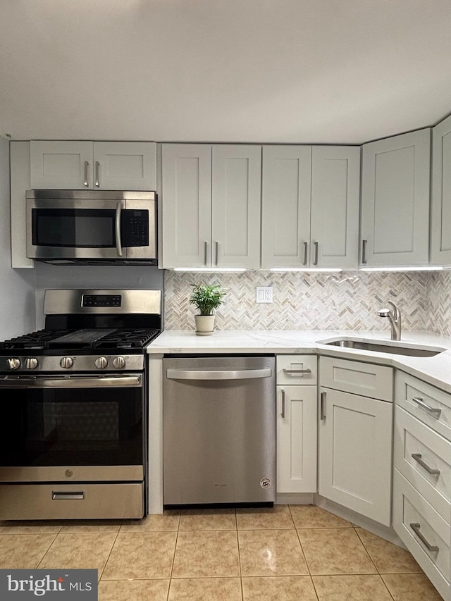 1536 Northgate Sq Unit 21, Reston, VA 20190 - kitchen with appliances with stainless steel finishes, a sink, light countertops, decorative backsplash, and light tile patterned floors