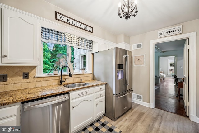 7600 Charleston Dr, Bethesda, MD 20817 - kitchen featuring stainless steel appliances, white cabinets, light wood finished floors, and backsplash
