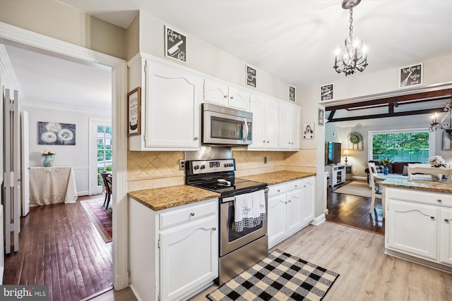 7600 Charleston Dr, Bethesda, MD 20817 - kitchen featuring stainless steel appliances, a chandelier, light wood finished floors, white cabinetry, and crown molding