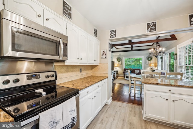 7600 Charleston Dr, Bethesda, MD 20817 - kitchen featuring stainless steel appliances, light wood-style flooring, a chandelier, white cabinetry, and backsplash