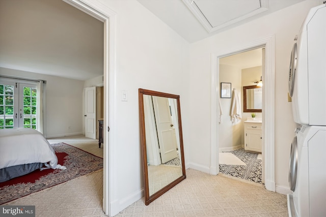 7600 Charleston Dr, Bethesda, MD 20817 - bedroom with stacked washing machine and dryer, light carpet, and connected bathroom