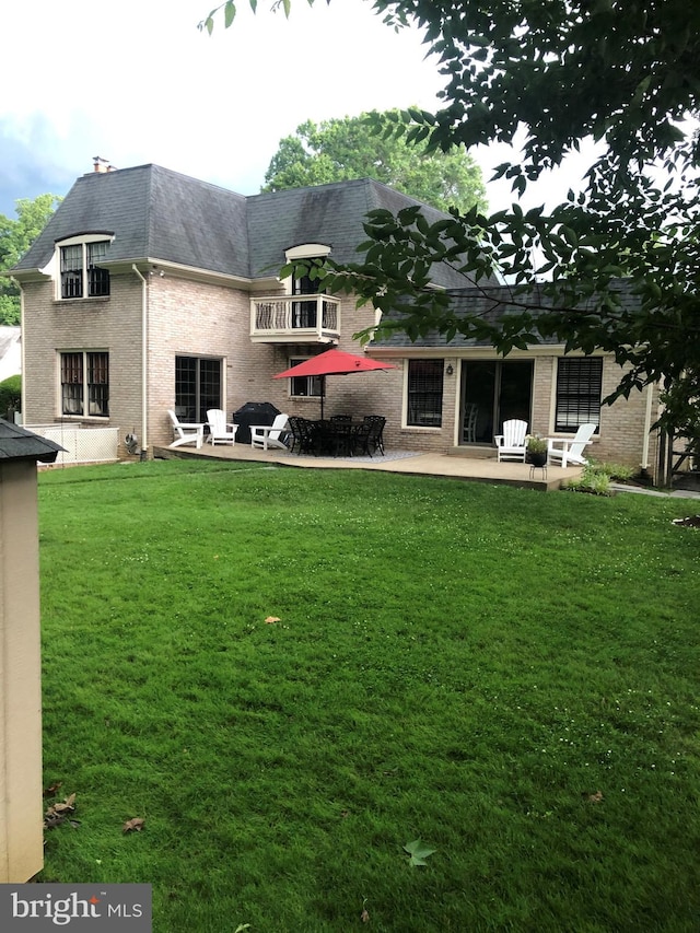 7600 Charleston Dr, Bethesda, MD 20817 - rear view of property featuring a yard, a patio, brick siding, and roof with shingles