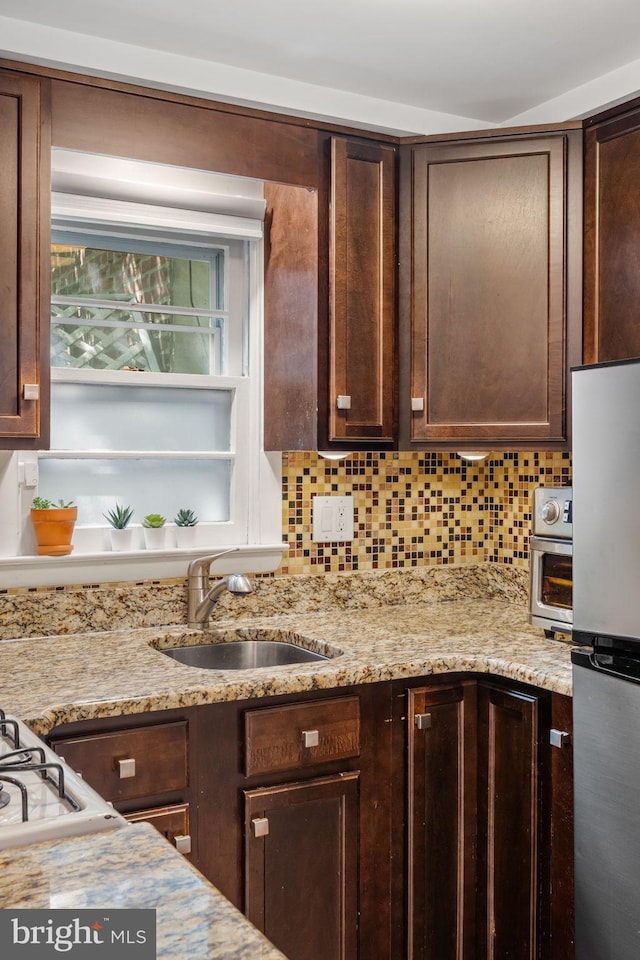 718 Addison St Unit B, Philadelphia, PA 19147 - kitchen with freestanding refrigerator, dark brown cabinets, backsplash, and light stone counters