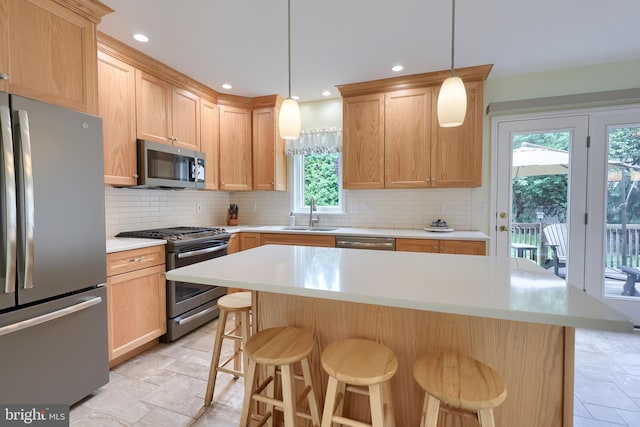 1350 Hyde Park Dr, Lancaster, PA 17601 - kitchen with appliances with stainless steel finishes, a sink, light countertops, a breakfast bar area, and decorative backsplash
