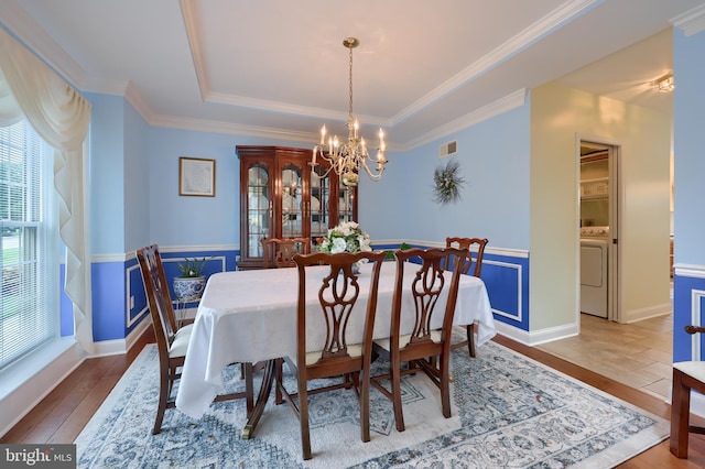 1350 Hyde Park Dr, Lancaster, PA 17601 - dining space with a chandelier, wood-type flooring, a raised ceiling, washer / dryer, and ornamental molding