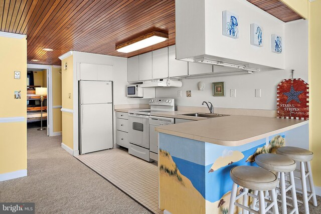 11400 Coastal Hwy Unit 8G, Ocean City, MD 21842 - kitchen featuring white appliances, wood ceiling, a sink, a peninsula, and light countertops
