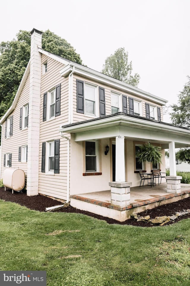 1806 Brunnerville Rd, Lititz, PA 17543 - view of front of property featuring a chimney, covered porch, heating fuel, and a front yard