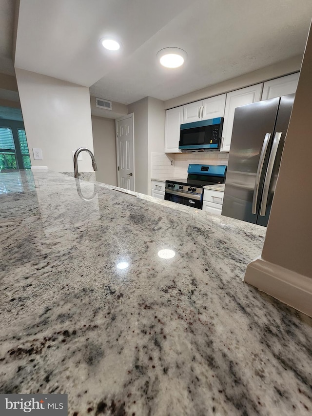 1002 Downing Ct Unit 1002-B, Bel Air, MD 21014 - kitchen with stainless steel appliances, light stone counters, white cabinetry, decorative backsplash, and a sink