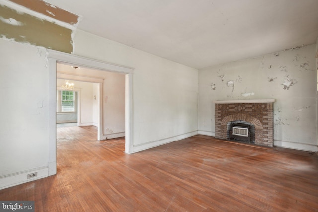 4100 Jenifer St NW, Washington, DC 20015 - unfurnished living room featuring wood finished floors, a brick fireplace, a chandelier, and baseboards