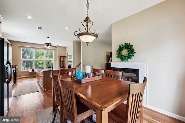 24830 Showbarn Cir, Damascus, MD 20872 - dining area with light wood-type flooring, baseboards, ceiling fan, recessed lighting, and a fireplace