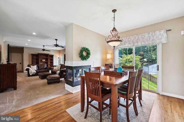 24830 Showbarn Cir, Damascus, MD 20872 - dining room featuring recessed lighting, a multi sided fireplace, light wood finished floors, a ceiling fan, and baseboards