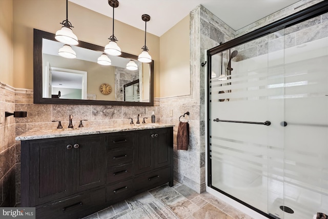 24830 Showbarn Cir, Damascus, MD 20872 - bathroom featuring tile walls, double vanity, a shower stall, vaulted ceiling, and stone finish floors