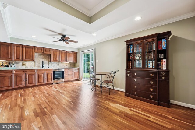 24830 Showbarn Cir, Damascus, MD 20872 - kitchen featuring a sink, light wood-type flooring, crown molding, decorative backsplash, and brown cabinetry