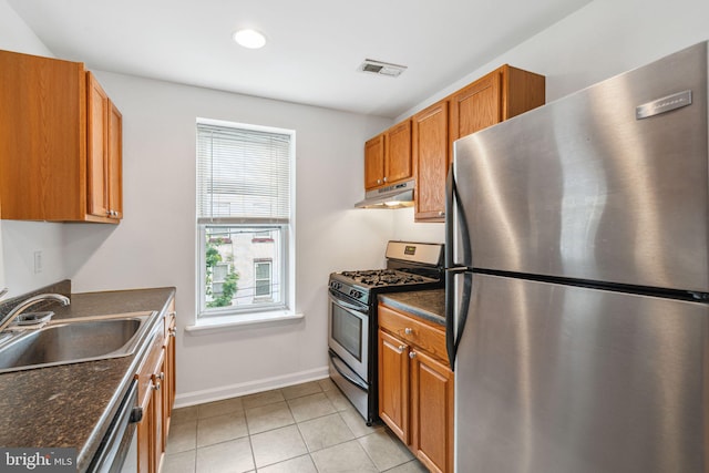 909 S 20th St Unit 3, Philadelphia, PA 19146 - kitchen featuring stainless steel appliances, under cabinet range hood, a sink, baseboards, and brown cabinetry