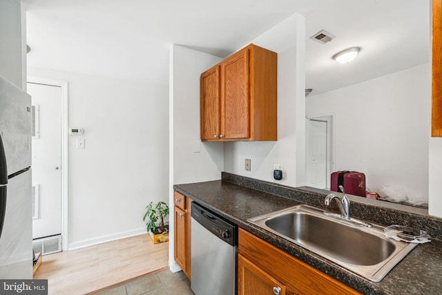 909 S 20th St Unit 3, Philadelphia, PA 19146 - kitchen featuring stainless steel appliances, a sink, dark countertops, brown cabinetry, and light tile patterned floors