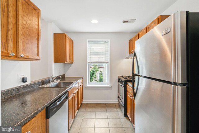 909 S 20th St Unit 3, Philadelphia, PA 19146 - kitchen featuring stainless steel appliances, a sink, under cabinet range hood, dark countertops, and brown cabinetry