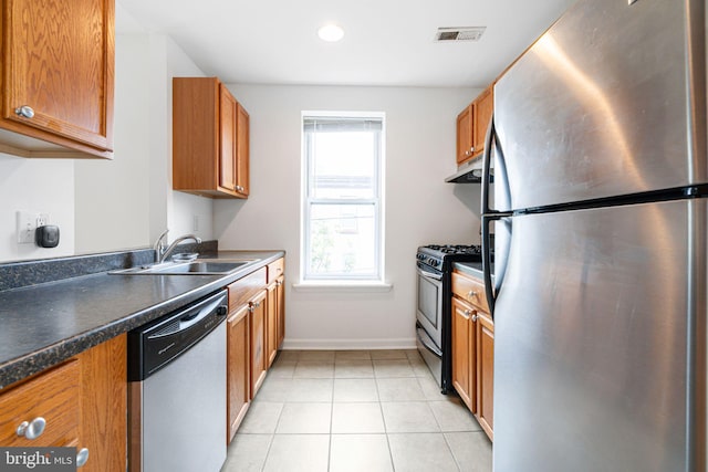 909 S 20th St Unit 3, Philadelphia, PA 19146 - kitchen featuring appliances with stainless steel finishes, under cabinet range hood, a sink, brown cabinets, and recessed lighting