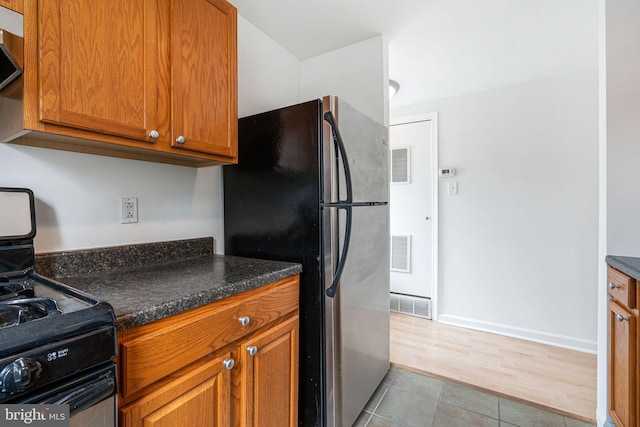 909 S 20th St Unit 3, Philadelphia, PA 19146 - kitchen with gas stove, freestanding refrigerator, brown cabinets, and light tile patterned floors
