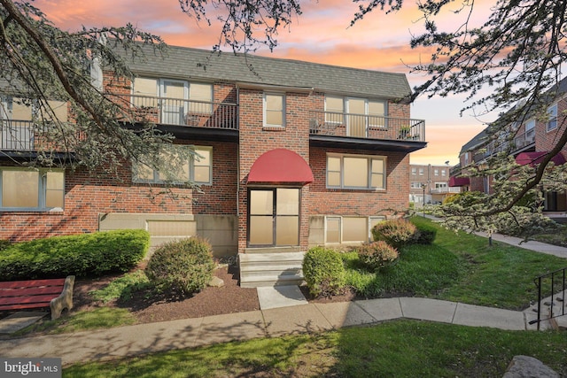 6901 Valley Ave Unit H2, Philadelphia, PA 19128 - front facade with a balcony, brick siding, entry steps, and a yard