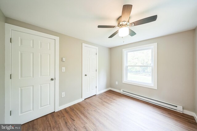 33 Lucretius Trl, Albrightsville, PA 18210 - unfurnished bedroom featuring a baseboard heating unit, wood finished floors, baseboards, and a ceiling fan