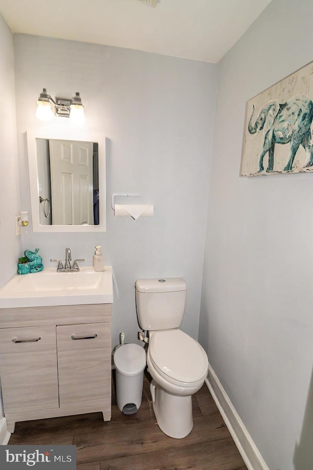 386 Braddock Rd, Smyrna, DE 19977 - half bathroom featuring wood finished floors, vanity, toilet, and baseboards