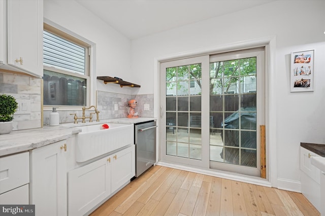 2342 W Seybert St, Philadelphia, PA 19121 - kitchen with dishwasher, a sink, backsplash, white cabinets, and light wood-style flooring