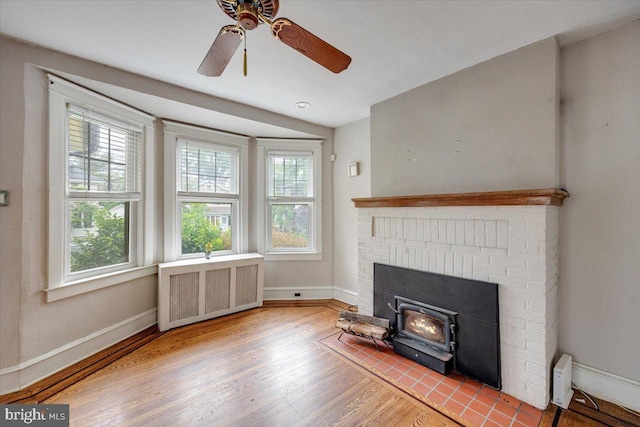 344 Clearbrook Ave, Lansdowne, PA 19050 - unfurnished living room featuring radiator heating unit, wood finished floors, plenty of natural light, and a wood stove