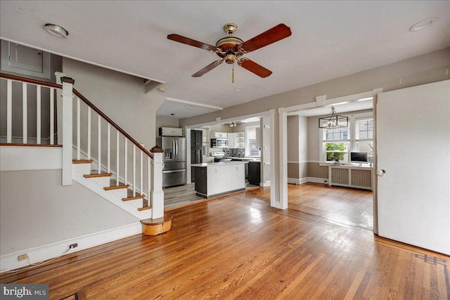 344 Clearbrook Ave, Lansdowne, PA 19050 - unfurnished living room with radiator, ceiling fan, light wood finished floors, stairway, and baseboards