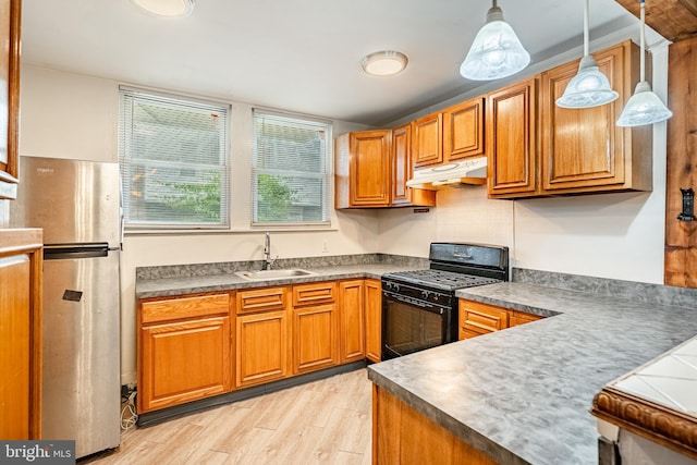 4749 Marple St, Philadelphia, PA 19136 - kitchen with black gas stove, a sink, freestanding refrigerator, under cabinet range hood, and light wood-style flooring
