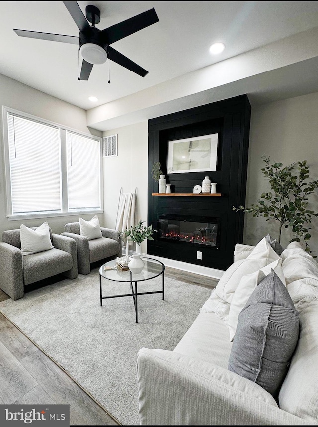2116 E Hoffman St, Baltimore, MD 21213 - living room featuring wood finished floors, ceiling fan, a glass covered fireplace, and recessed lighting