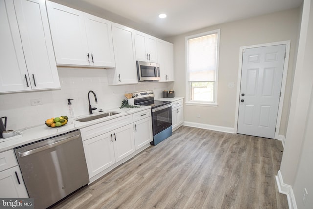 2116 E Hoffman St, Baltimore, MD 21213 - kitchen with stainless steel appliances, backsplash, white cabinetry, light wood-type flooring, and recessed lighting