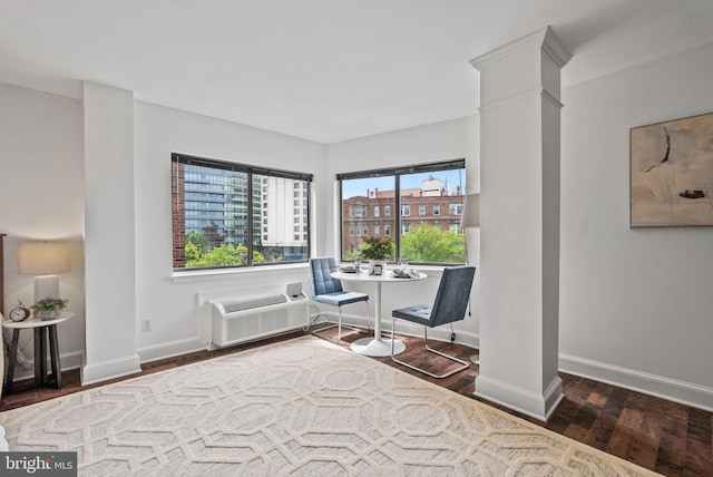 1825 T St NW Unit 701, Washington, DC 20009 - living area featuring wood finished floors, a wall mounted air conditioner, baseboards, and decorative columns
