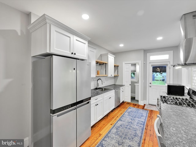 546 N Plum St, Lancaster, PA 17602 - kitchen with appliances with stainless steel finishes, open shelves, wall chimney range hood, white cabinets, and decorative backsplash