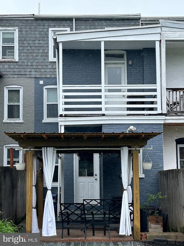 546 N Plum St, Lancaster, PA 17602 - rear view of property featuring a balcony, brick siding, and mansard roof