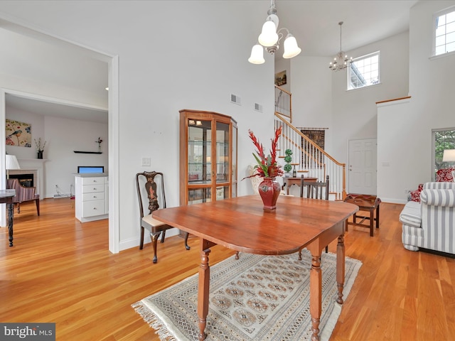 1082 Stillwood Cir, Lititz, PA 17543 - dining room featuring stairway, a chandelier, a high ceiling, and light wood-type flooring