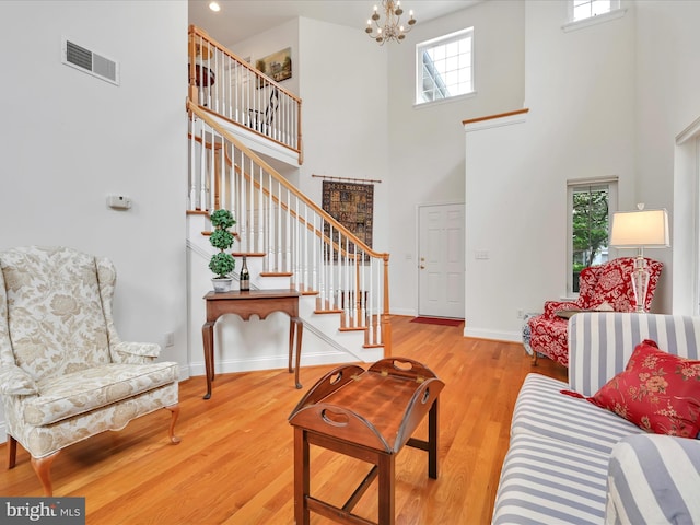 1082 Stillwood Cir, Lititz, PA 17543 - living room featuring a towering ceiling, stairs, plenty of natural light, a chandelier, and wood finished floors